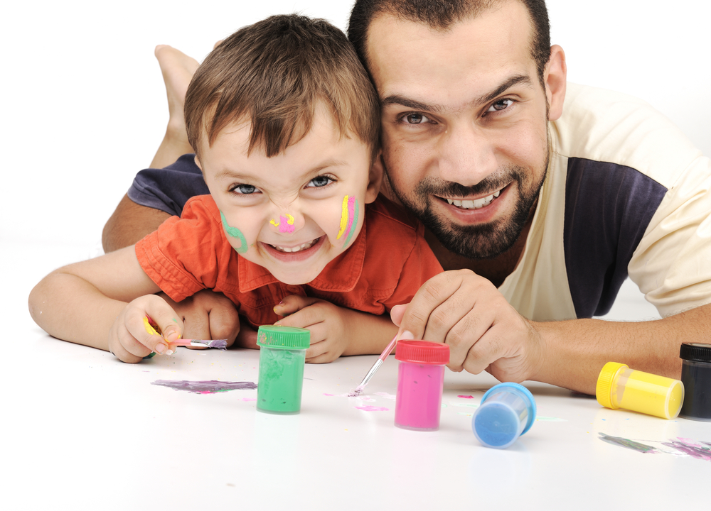 Father and kid playing with paint colors